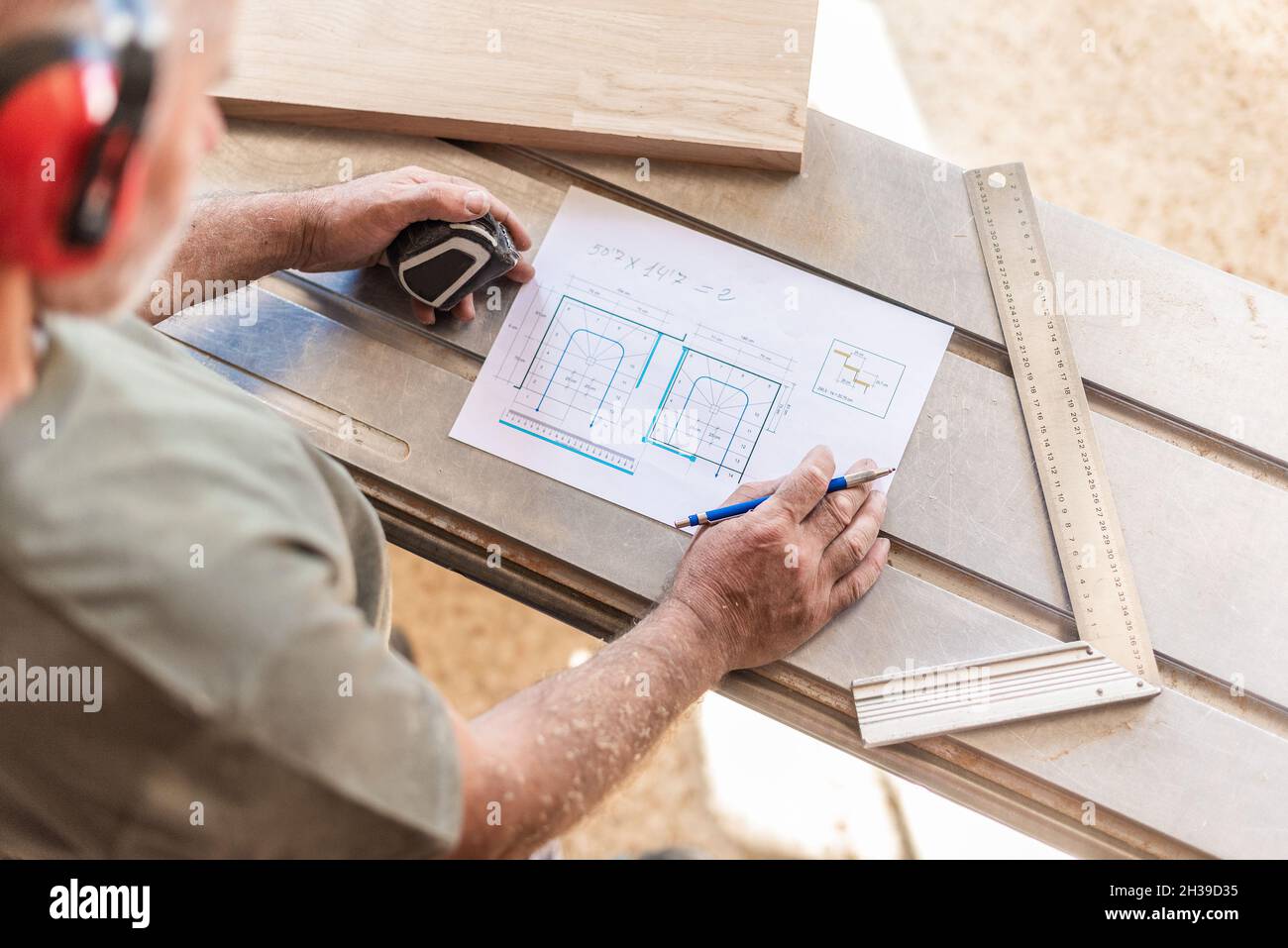 personne qui dessine sur une planche en bois avec mètre ruban et règle Banque D'Images