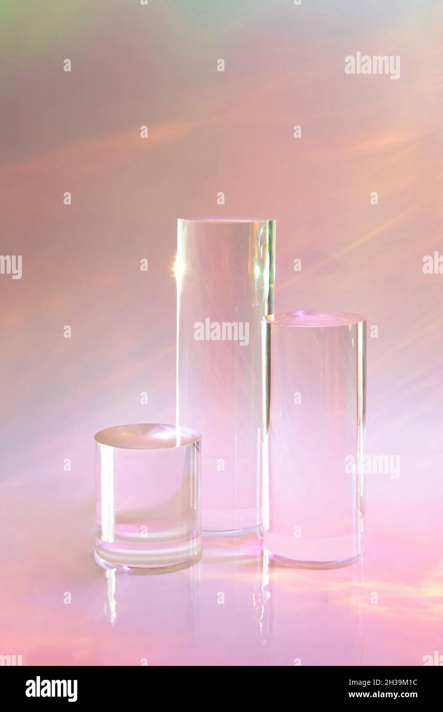 trois podiums en verre transparent sur fond rose pastel Banque D'Images