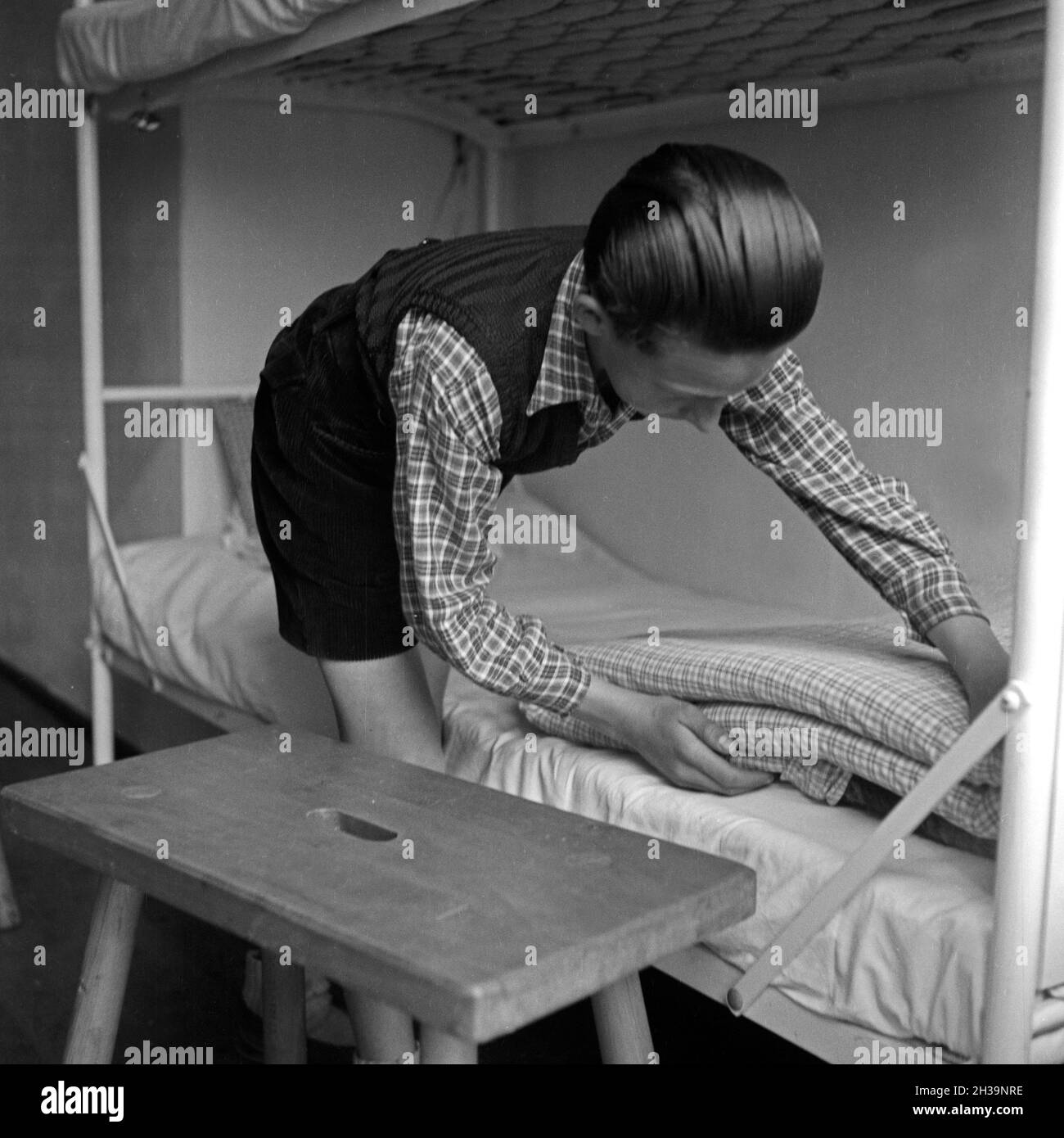 In der Junge Adolf-Hitler-Jugendherberge à Berchtesgaden beim Betten machen, Deutschland 1930er Jahre. Garçon au Adolf-Hitler-auberge de jeunesse à Berchtesgaden préparer leurs lits, Allemagne 1930. Banque D'Images