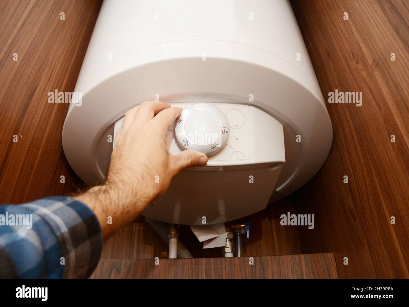 Homme à la main, régler la chaleur dans la chaudière à condensation, la chaudière Combi pour économiser l'énergie de la maison.Concept de la chaudière à gaz, des fournitures de la chaudière. Banque D'Images