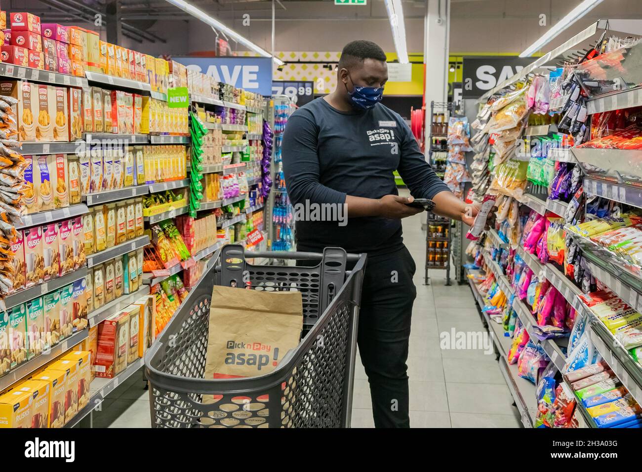 Cape Town, Afrique du Sud - 9 septembre 2021 : un membre du personnel cueille des produits à partir de l'étagère pour un service de livraison express à domicile Banque D'Images