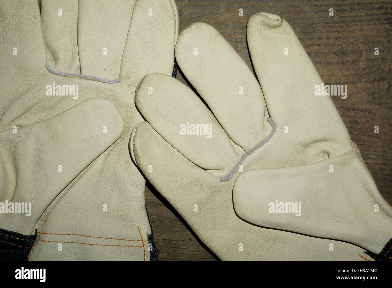 Gros plan de gants de travail en cuir sur fond de bois Banque D'Images