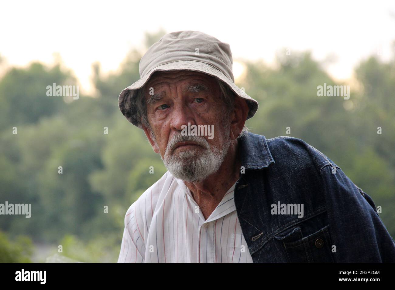 Senior retraité homme aîné dans le parc à l'extérieur avec espace de copie.Portrait seul pensif homme dans chapeau de seau.80 ans.Gros plan.Mise au point douce Banque D'Images