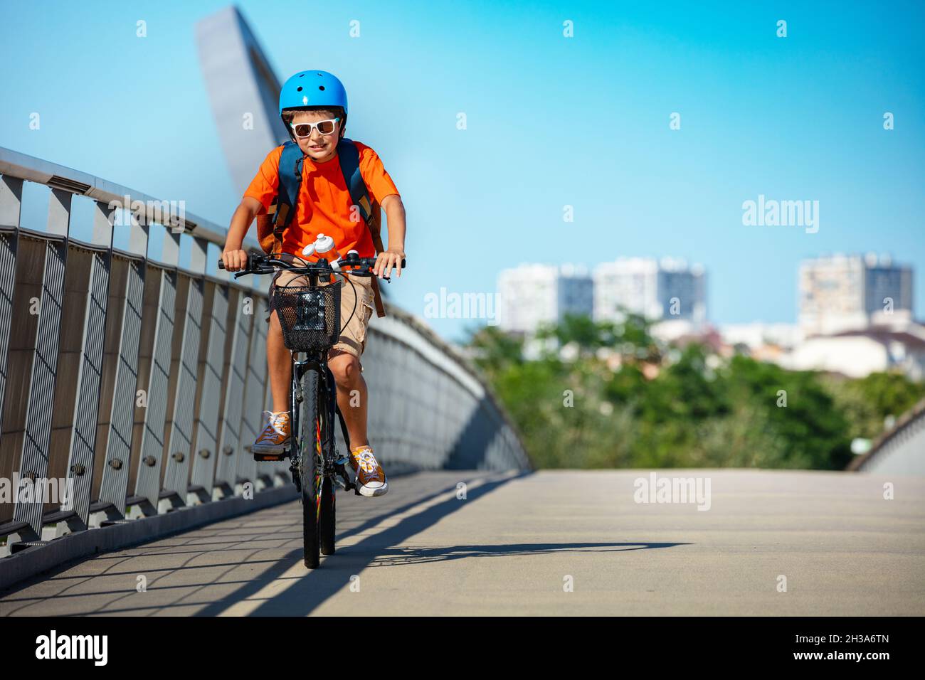 Garçon dans un casque bleu avec vélo à dos Banque D'Images