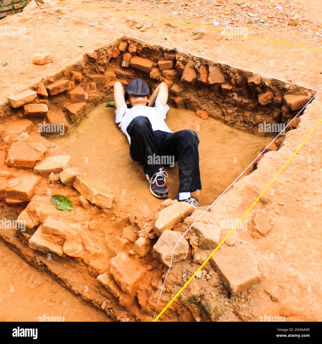 Un étudiant d'université qui a déposé à l'intérieur d'une boîte d'excavation que lui et son équipe ont creusé au temple de Muaro Jambi, en Indonésie. Banque D'Images