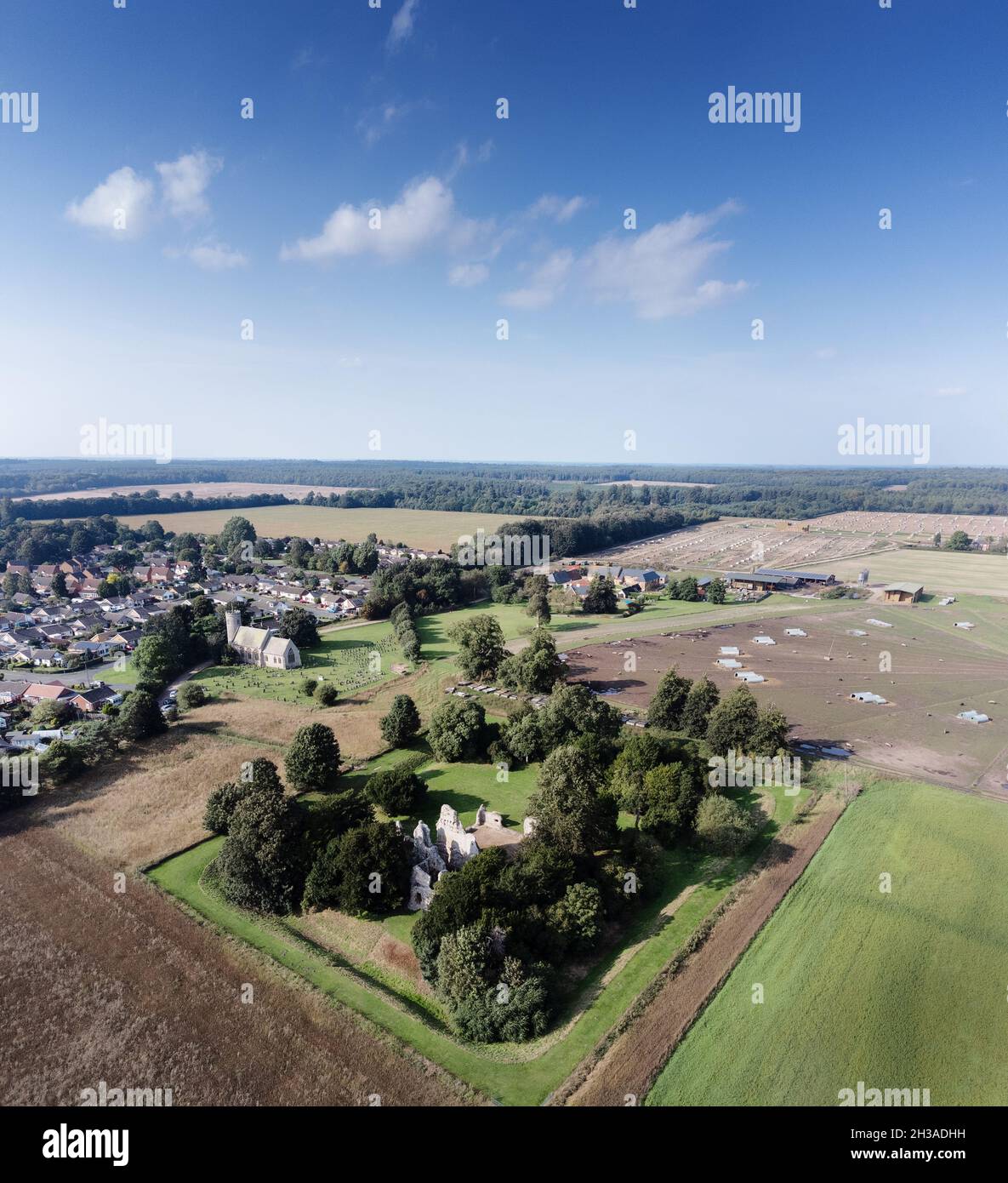 Image aérienne au-dessus du village de Weeting, Brandon en Angleterre avec l'église et les ruines du château de Weeting en premier plan Banque D'Images