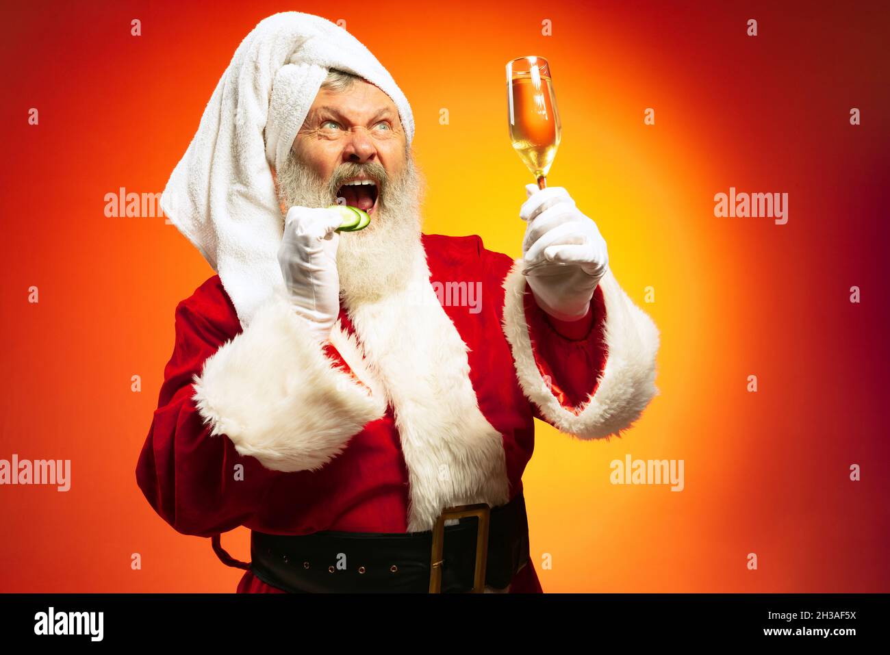 Drole D Homme Age Portant Le Towl Blanc Et Le Costume Du Pere Noel Congrats Tout Le Monde Avec Le Nouvel An 2022 Isole Sur Fond Jaune Rouge Au Neon Photo Stock