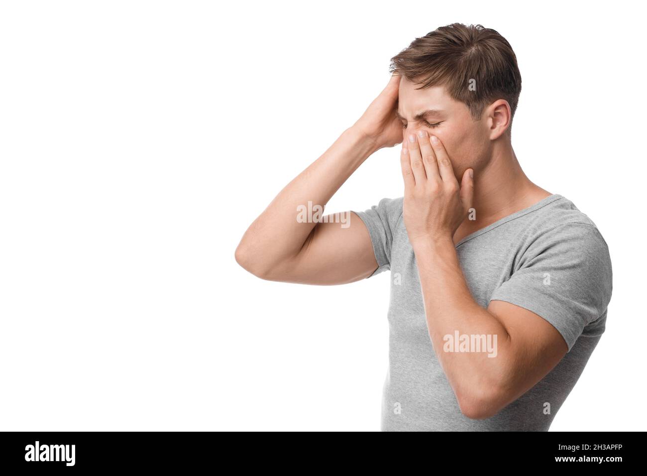 Bouleversé jeune homme caucasien souffrant de maux de tête, nez qui coule, se sentir mal Banque D'Images