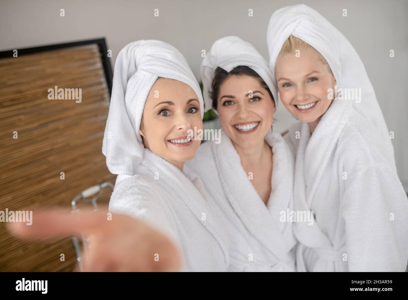 Des femmes souriantes et gaies dans des peignoirs blancs Banque D'Images