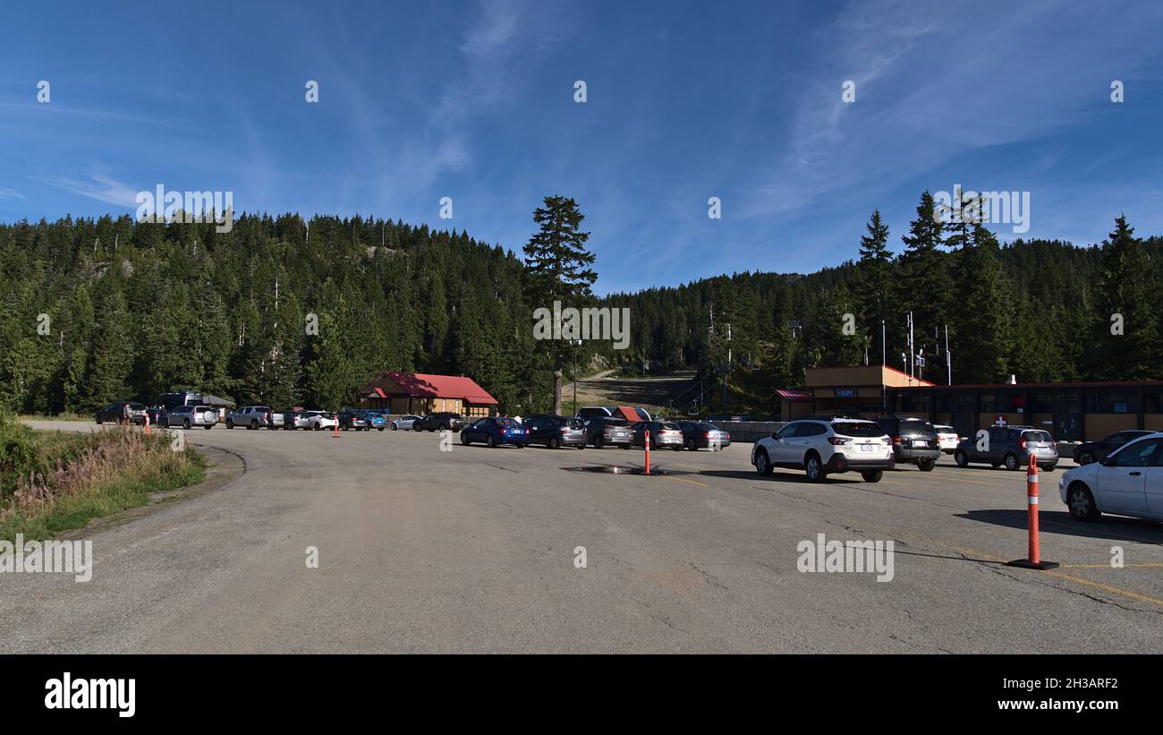 Les voitures se garent sur le parking du parc provincial du Mont Seymour près de Mount Seymour Resort en automne, par beau temps, avec forêt en arrière-plan. Banque D'Images