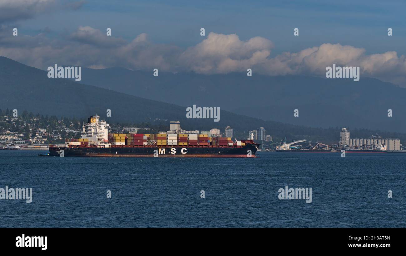 Vue de Burrard Inlet près de Vancouver avec un navire à conteneurs exploité par la Mediterranean Shipping Company (MSC) passant par les montagnes en arrière-plan. Banque D'Images