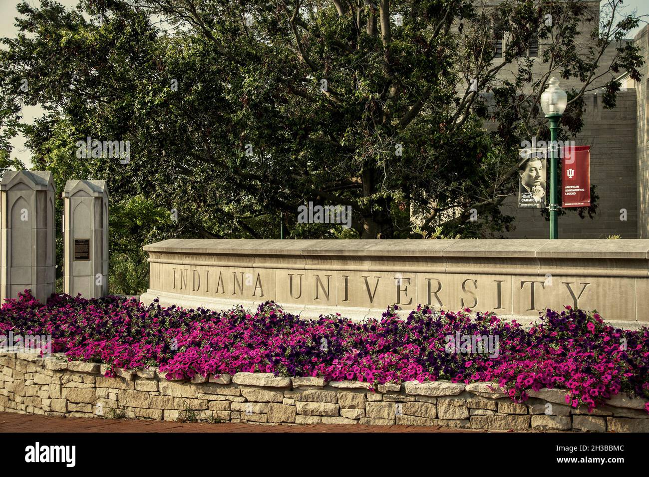 07 30 2021 Bloomington USA - Gate into Indiana University avec une jardinière pleine de fleurs rose vif et un panneau sur le lampost d'Alumni Hogy Carmichael Ameri Banque D'Images