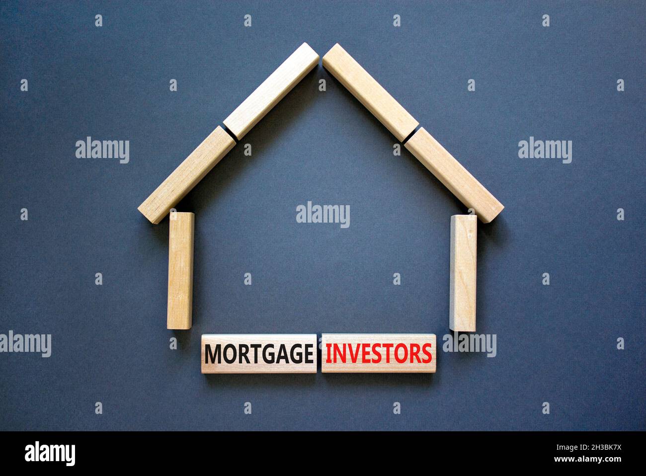 Symbole des investisseurs hypothécaires.Mots-clés 'Mortgage Investors' sur des blocs de bois près de la maison en bois miniature.Magnifique fond gris.Affaires, morg Banque D'Images