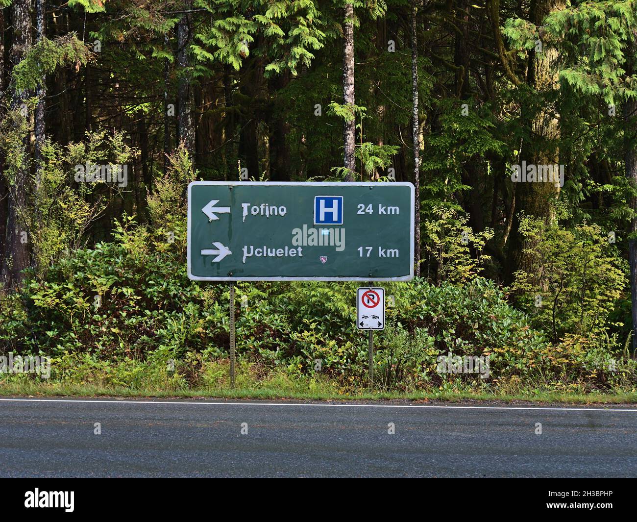 Vue de face du panneau de signalisation routière directionnel près de Rainforest Trail indiquant les directions et la distance de Tofino et Ucluelet.Concentrez-vous sur l'affiche. Banque D'Images