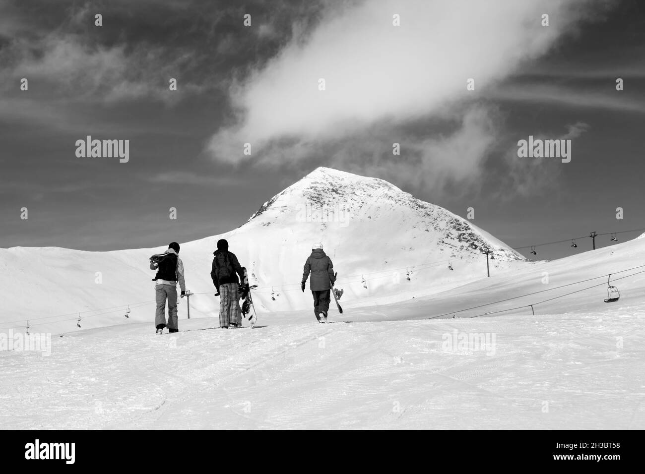 Trois snowboarders sur une pente enneigée dans les hautes montagnes d'hiver.Caucase, Géorgie, région de Gudauri.Image en noir et blanc. Banque D'Images