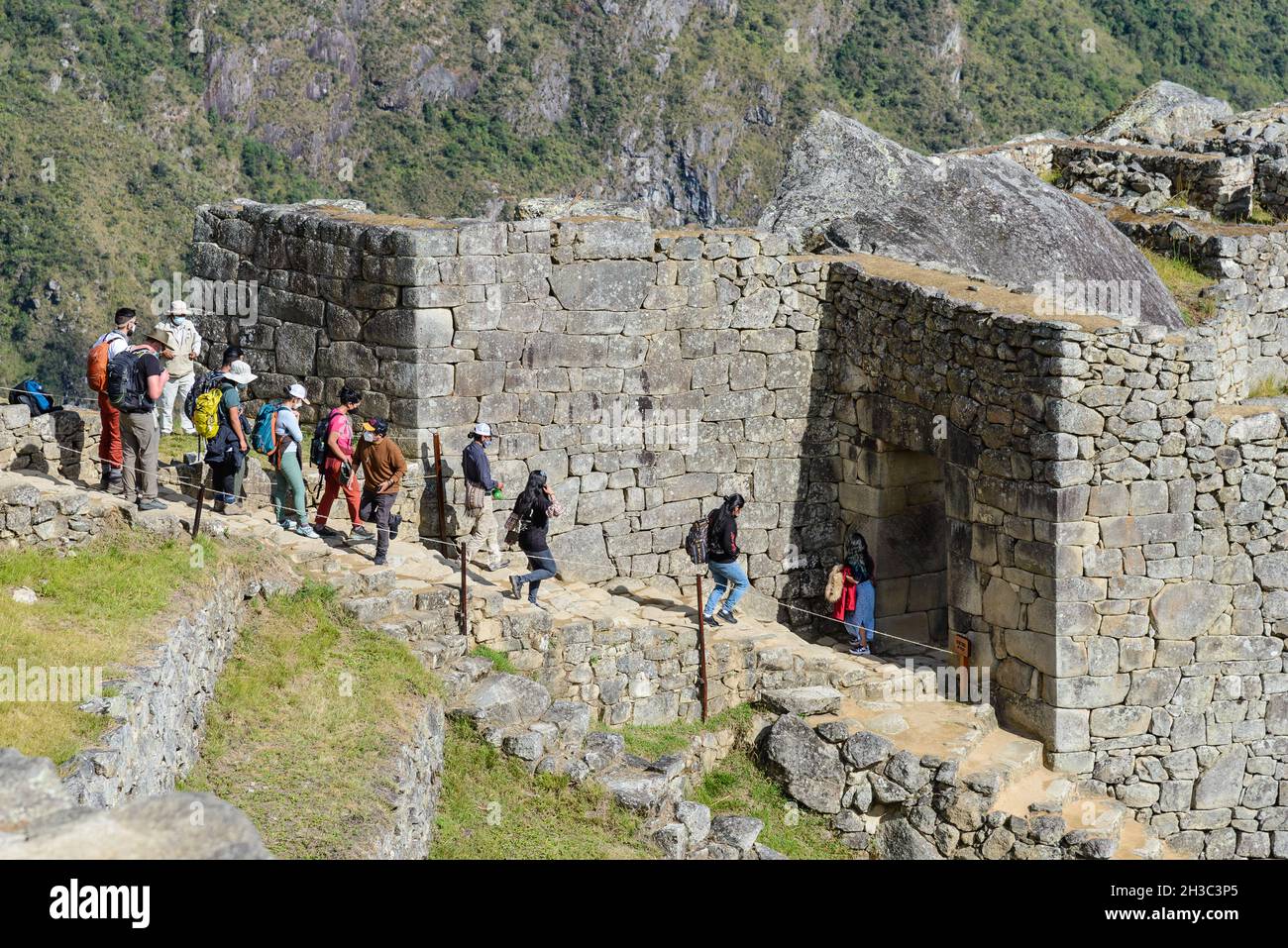 Les touristes marchant sur les escaliers en pierre pour entrer dans la porte de la ville.Machu Picchu, Cuzco, Pérou. Banque D'Images Les touristes marchant sur les escaliers en pierre pour entrer dans la porte de la ville.Machu Picchu, Cuzco, Pérou. Banque D'Images