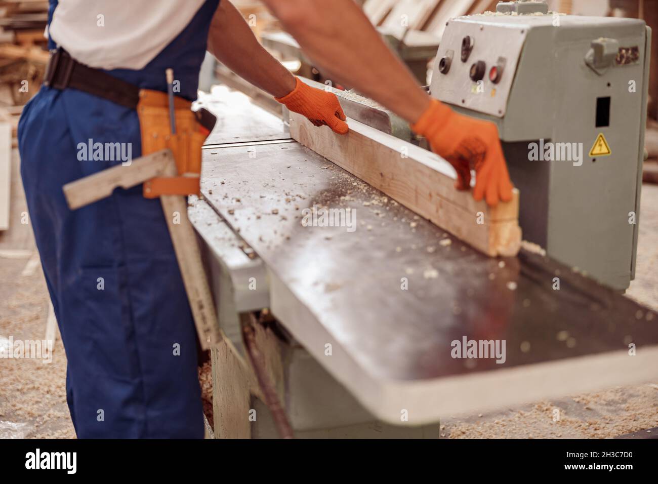 Menuisier mâle utilisant une machine à bois dans l'atelier Banque D'Images