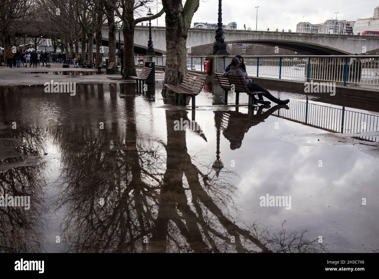 Londres, Royaume-Uni - 20 novembre 2020, les jeunes sont assis sur un banc, regardant la Tamise.Rive sud Banque D'Images