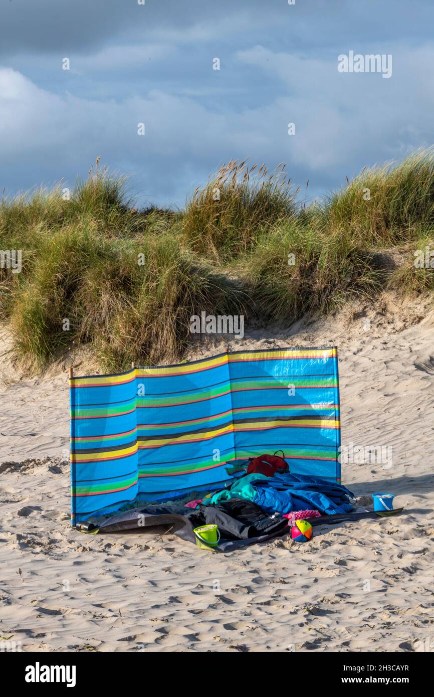 pause-vent sur une plage à studland dans dorset sur l'île de purbeck, la staycation, la coupe-vent déserte, les vêtements abandonnés et la coupe-vent sur la plage. Banque D'Images