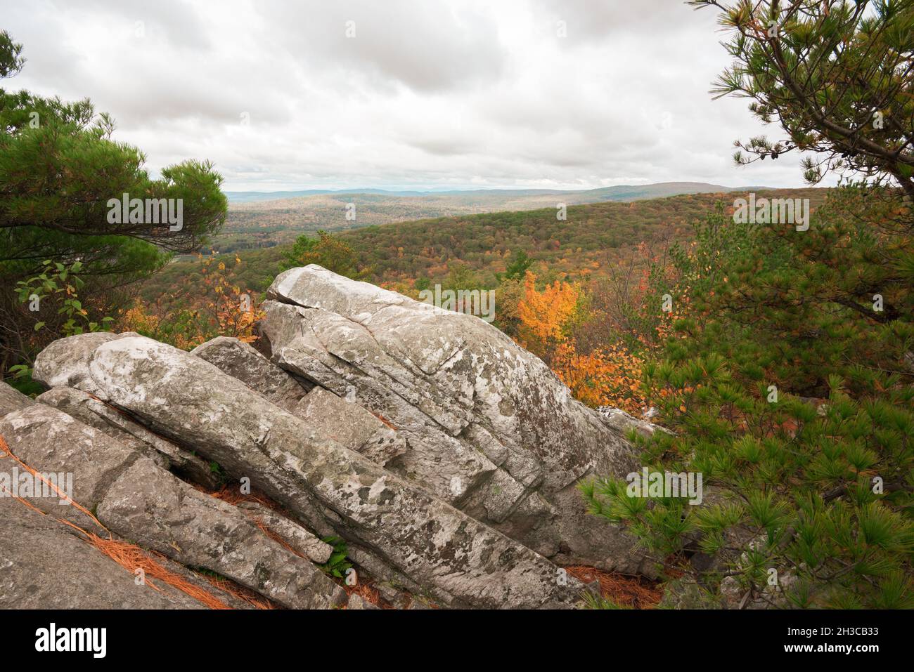 Flanc de coteau rocheux sur la montagne dans le Massachusetts le jour nuageux en automne avec feuillage d'automne pendant la saison d'octobre regardant au-dessus de la vallée Banque D'Images