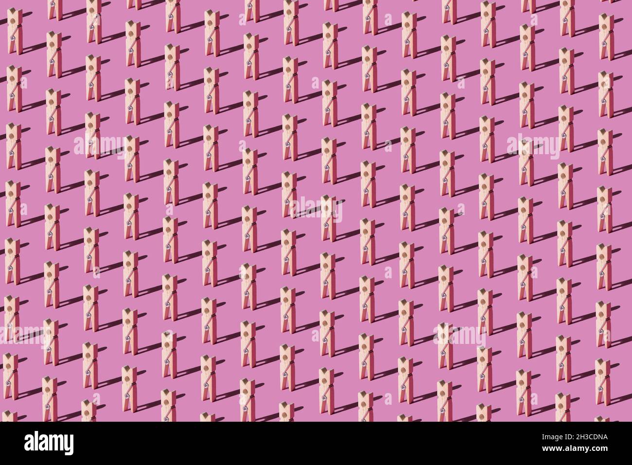 Motifs de chevilles en bois sur fond rose pastel.Vue de dessus.Concept de mode abstrait minimal. Banque D'Images