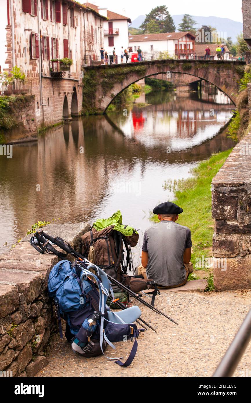 Pèlerin se reposant sur les rives de la Nive à Saint-Jean-pied-de-Port en marchant sur le Camino de Santiago sur le chemin de Saint-Jacques au-dessus des Pyrénées Banque D'Images