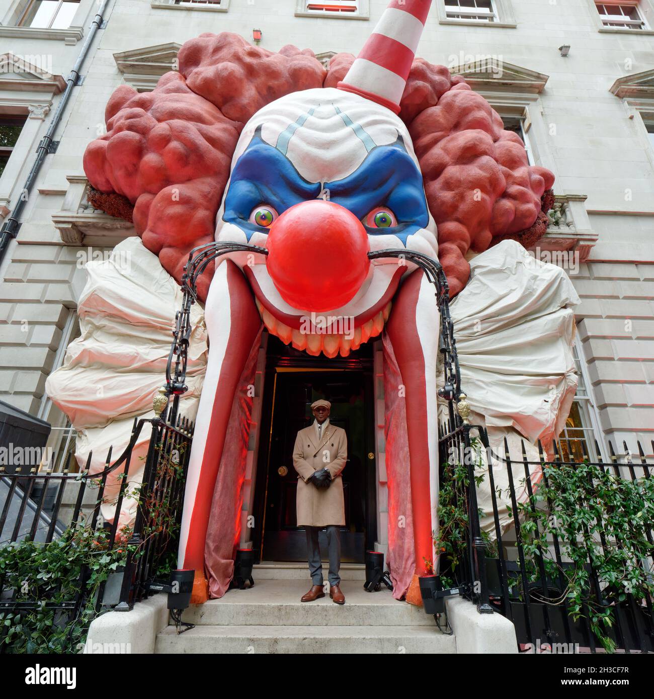 Un portier se tient à l'entrée du club privé Annabels de Berkeley Square avec une façade sur le thème de l'Halloween. Londres Banque D'Images