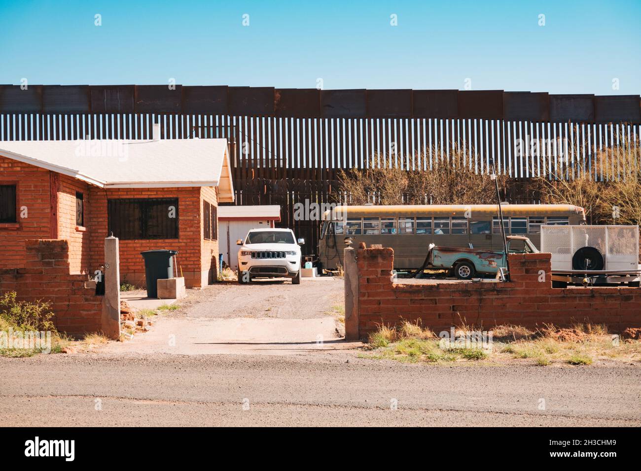 Le mur frontière entre les États-Unis et le Mexique sert également de barrière de cour arrière pour une maison dans la petite ville de Naco, en Arizona Banque D'Images