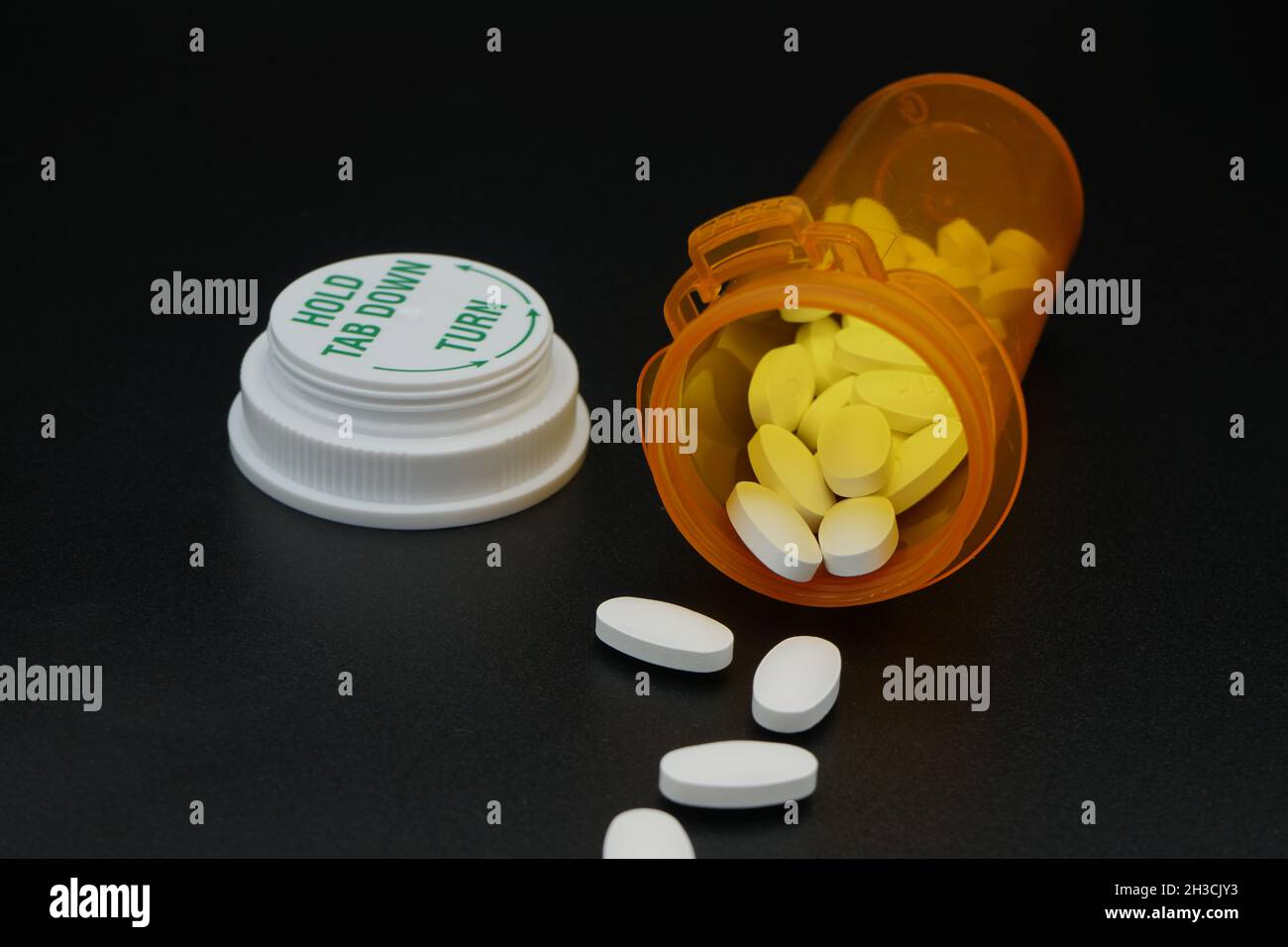 Pilules et flacon de pilule sur fond noir Banque D'Images