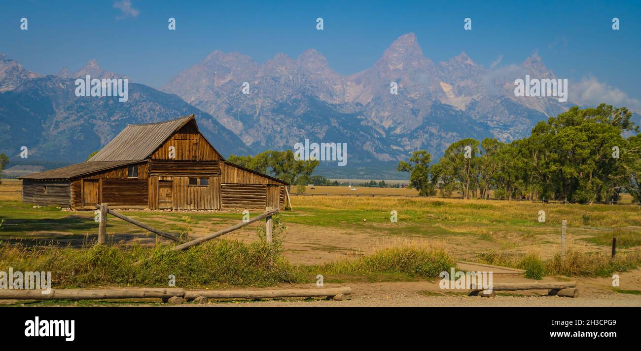 Grange en bois sur le quartier historique de Mormon Row avec la chaîne de montagnes Teton en arrière-plan Banque D'Images