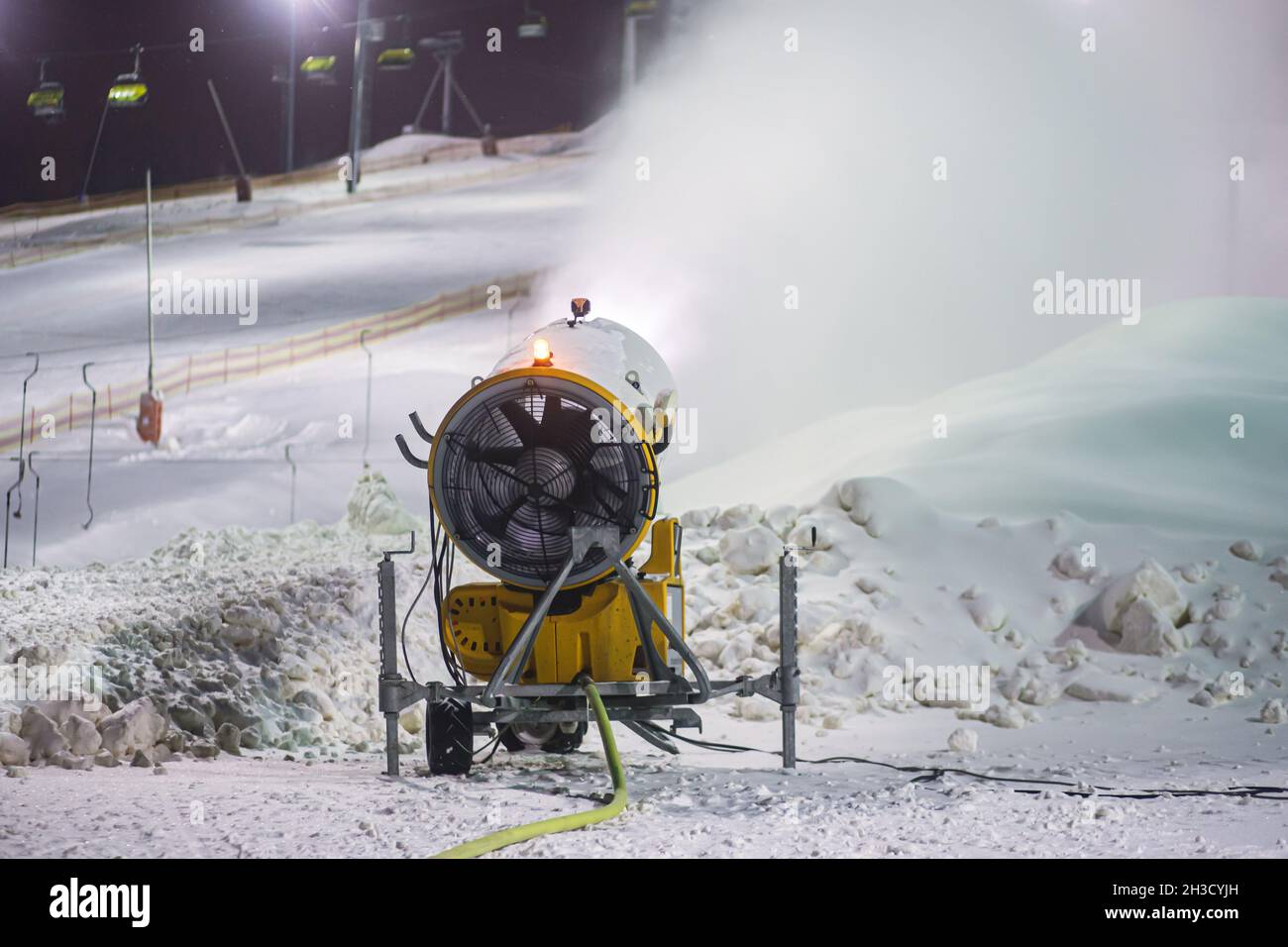 Canon à neige, machine à neige artificielle sur les pistes d'une station de ski, remontée mécanique et piste Banque D'Images