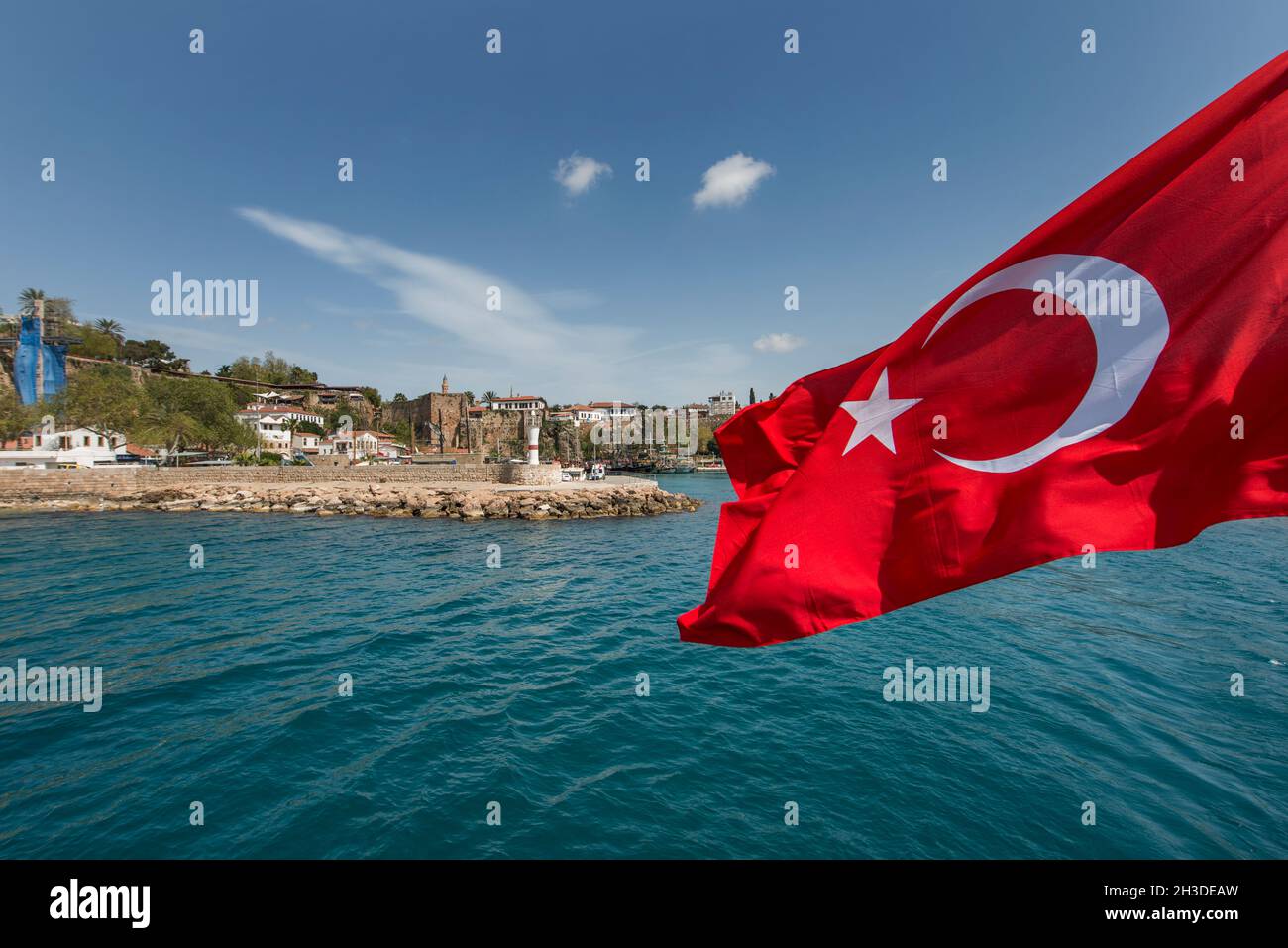 Visite touristique sur un bateau traversant les eaux de la Méditerranée avec un drapeau turc volant à la poupe Banque D'Images