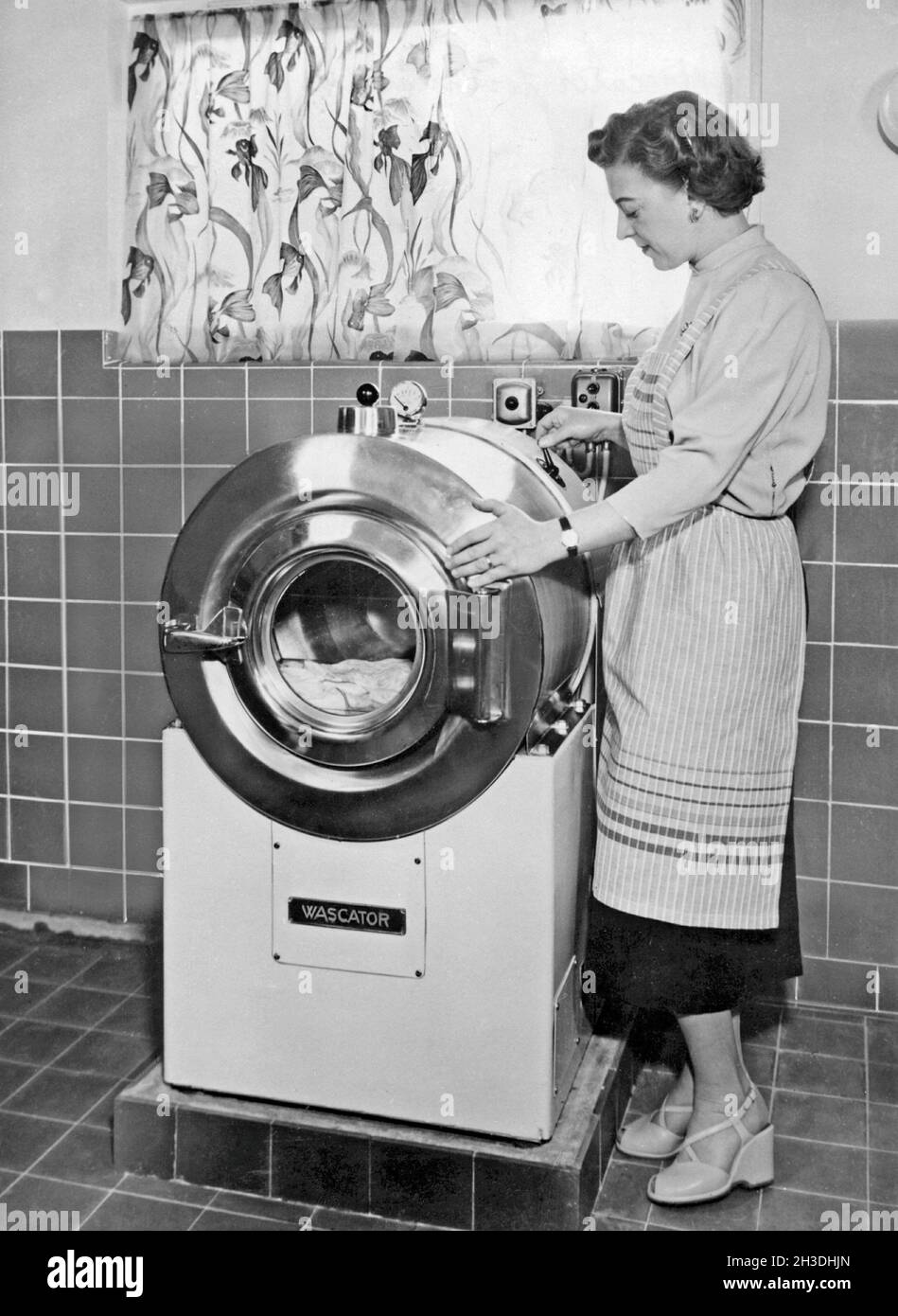 Faire la lessive dans les années 1950.Une dame fait la démonstration de la nouvelle machine à laver fabriquée par AB Wascator. Banque D'Images