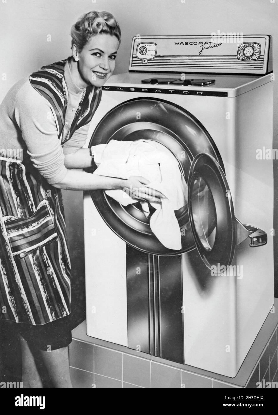 Faire la lessive dans les années 1950.Une dame présente la nouvelle machine à laver Wasc-O-Mat Junior fabriquée par AB Wascator. Banque D'Images