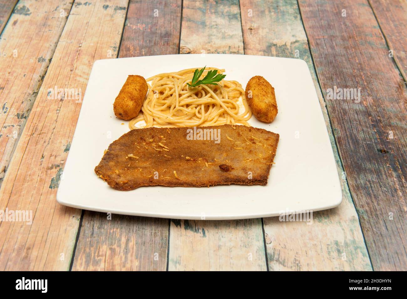 Schnitzel de veau avec spaghetti et croquettes sur plaque blanche Banque D'Images