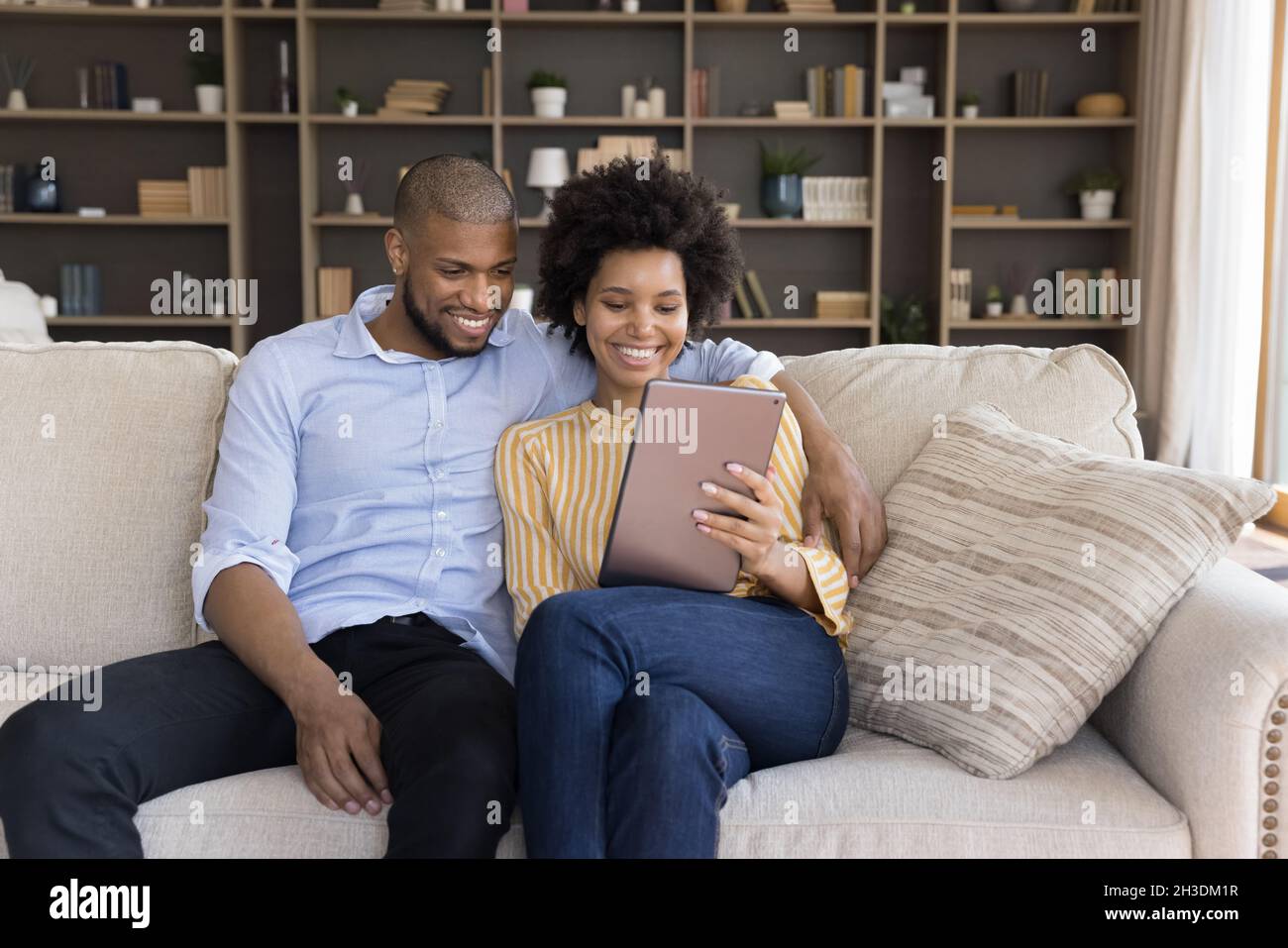 Un jeune couple afro-américain heureux utilisant une tablette. Banque D'Images