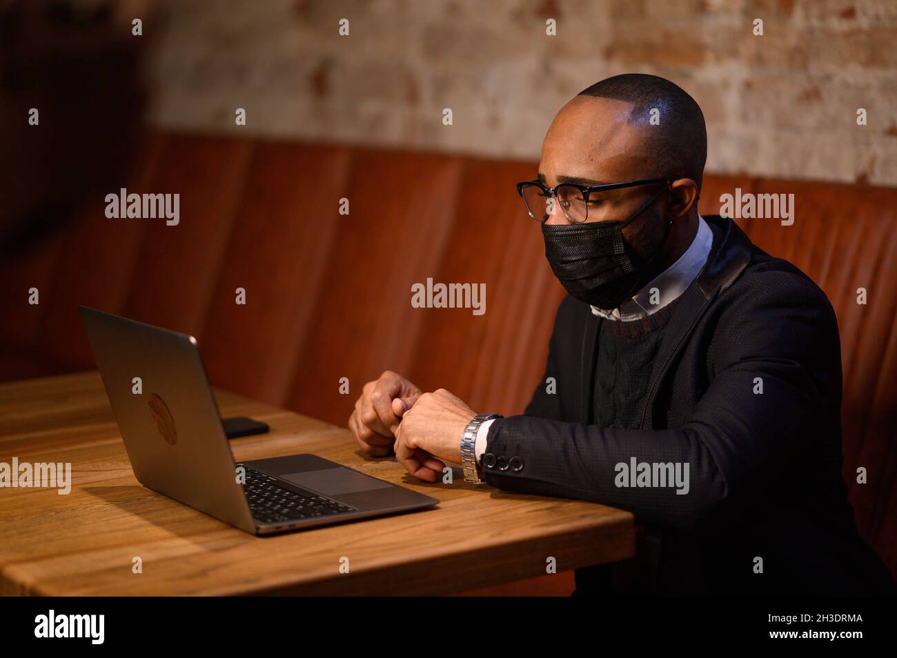 Un étudiant afro-américain travaille sur un ordinateur portable dans un café Banque D'Images