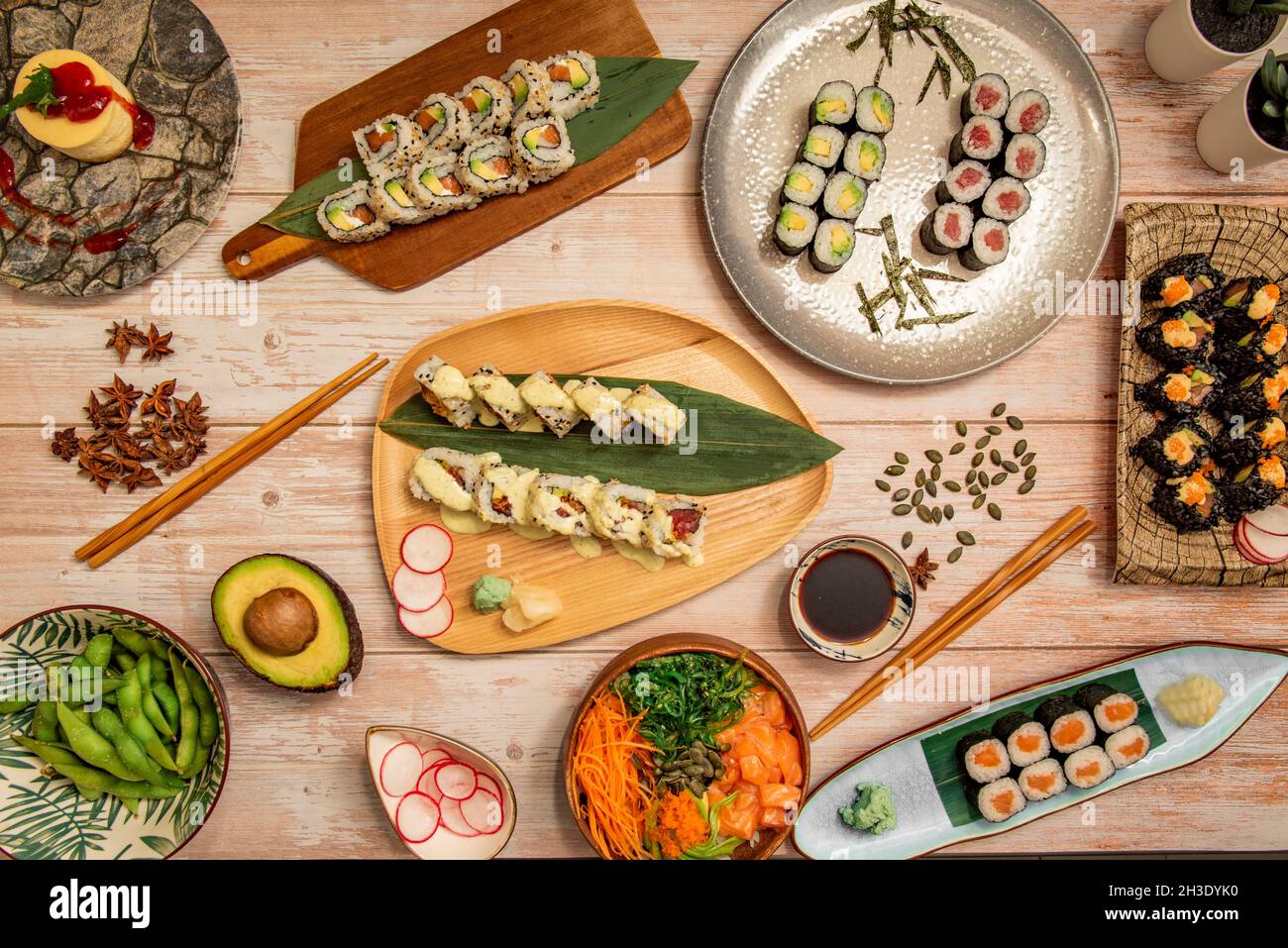 Vue de dessus de plats japonais, saumon maki, rouleau de californie uramaki avec graines de sésame, edamame, bol à saumon, salade wakame, anis étoilé,a Banque D'Images