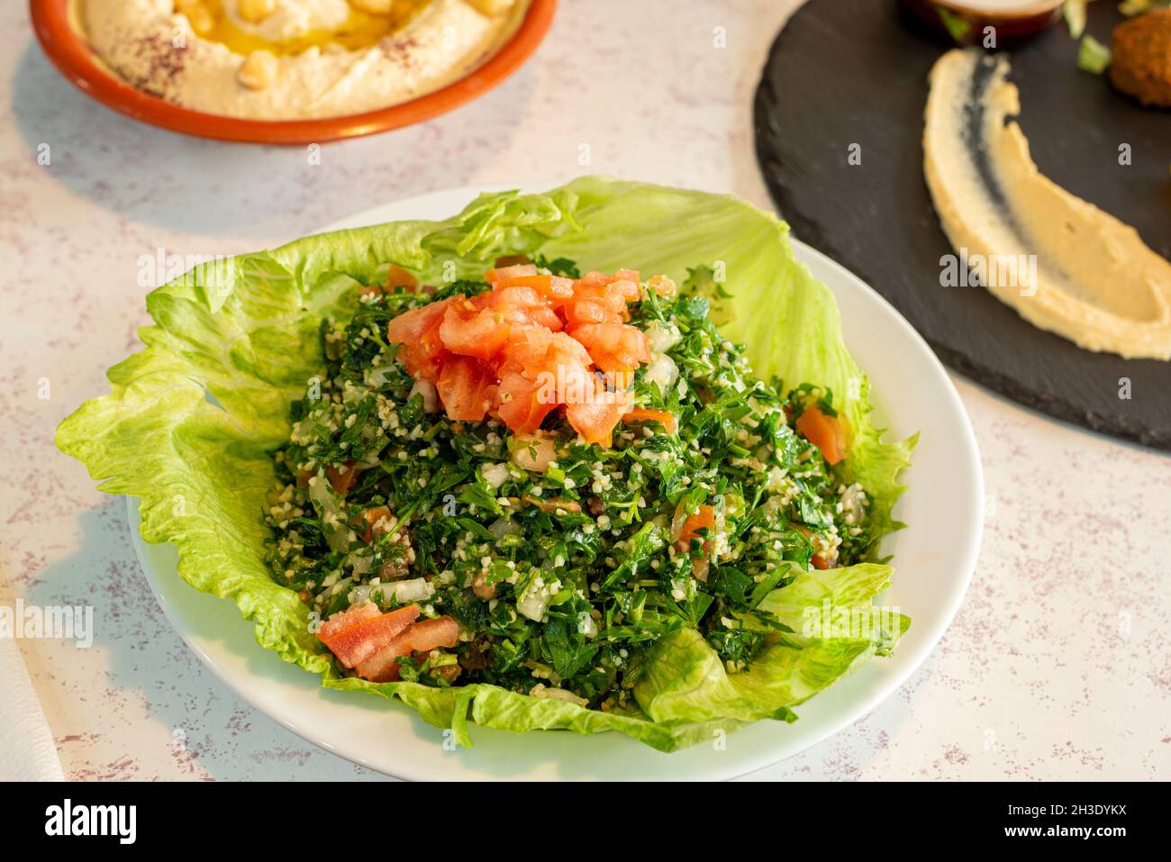 Salade d'herbes vertes turques avec tomates et tabouleh avec huile d'olive et sel Banque D'Images