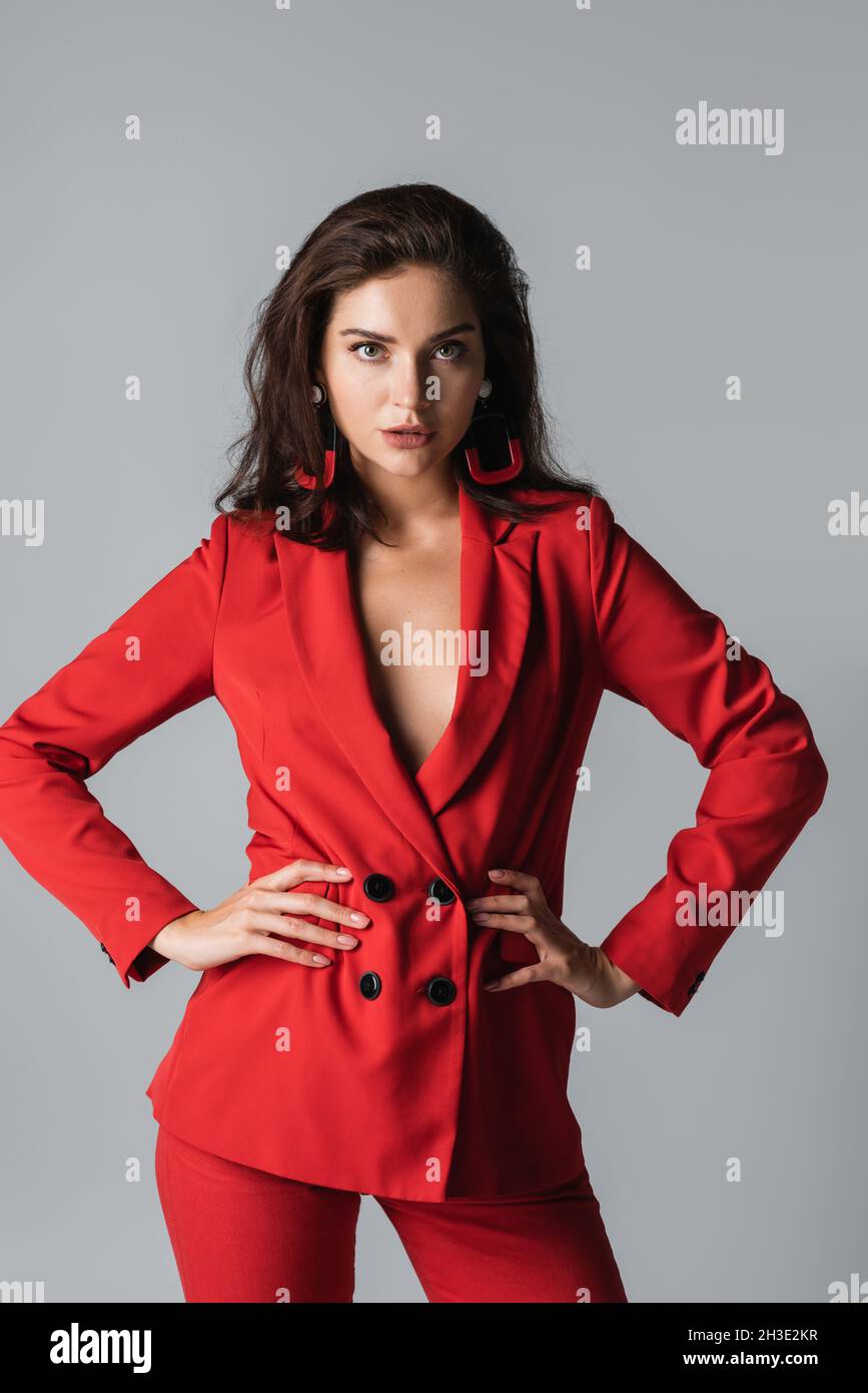 femme élégante en costume rouge posant et regardant la caméra tout en — free download