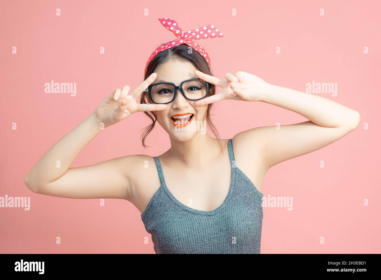 Photo de jolie fille excitée souriant deux V-signes couverture yeux isolé  couleur rose fond Photo Stock - Alamy