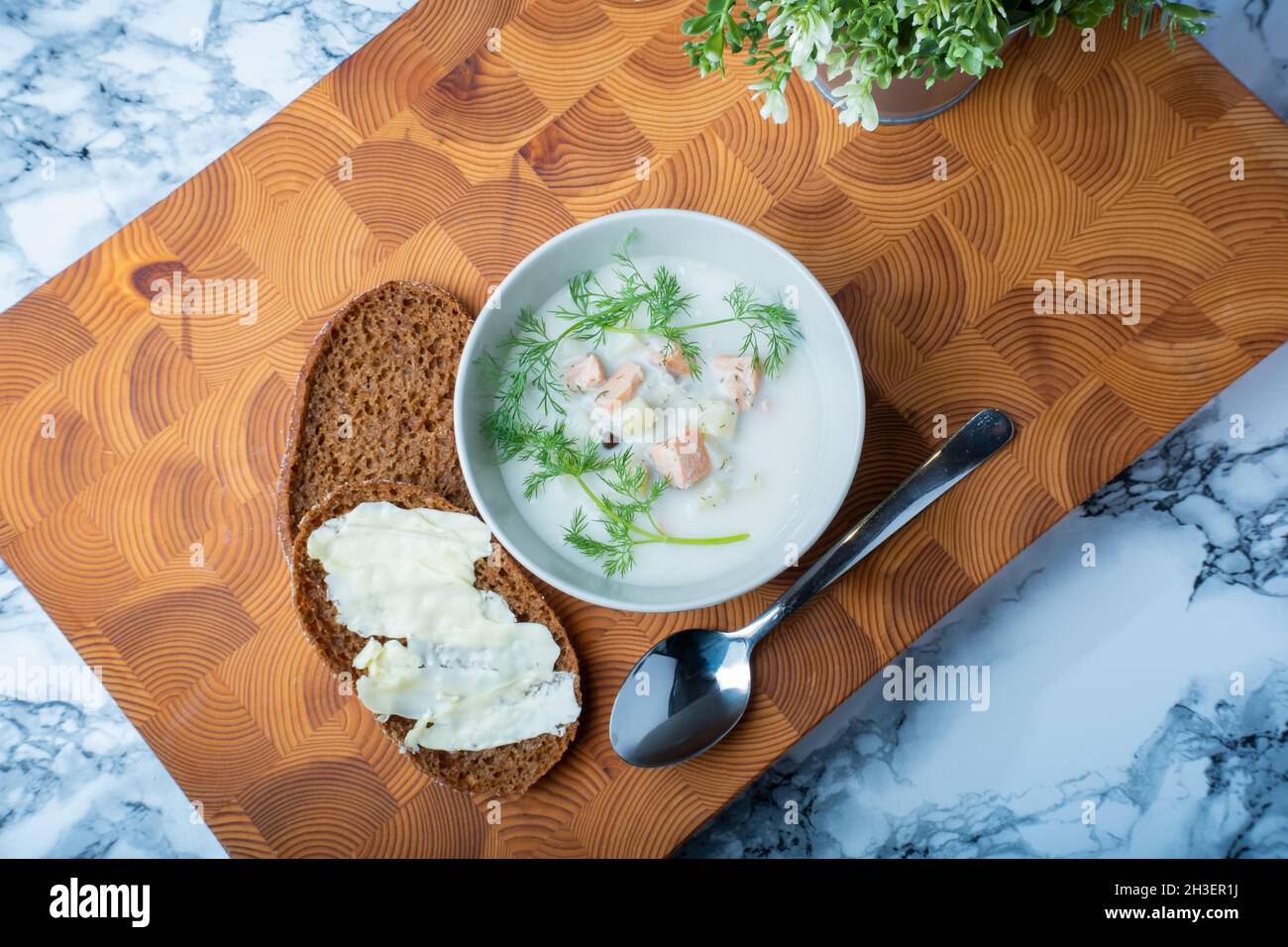 Helsinki / Finlande - 28 OCTOBRE 2021 : cuisine finlandaise traditionnelle : bol de soupe crémeuse au saumon avec garniture à l'aneth.Deux morceaux de pain de seigle sur le côté. Banque D'Images