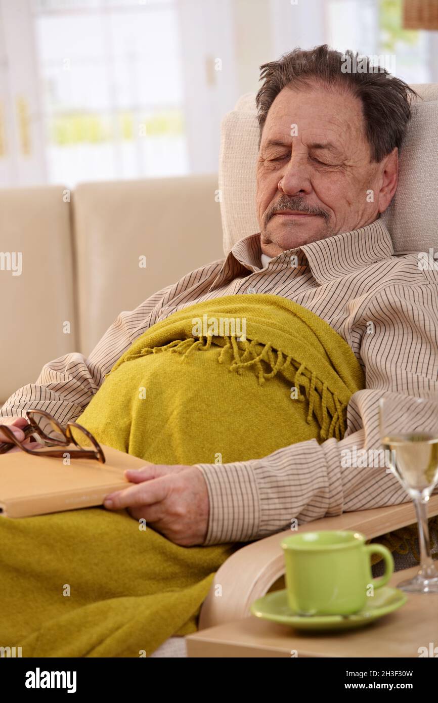 Senior man sleeping in armchair Banque D'Images