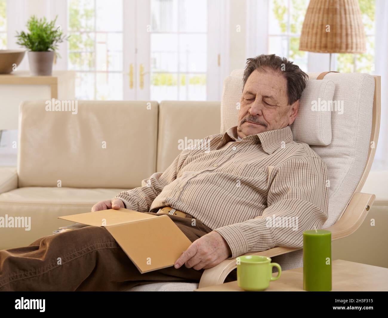 Senior man sleeping in armchair Banque D'Images