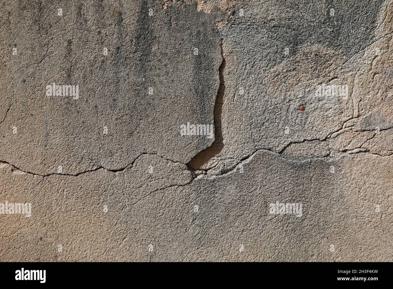 Le vieux mur de briques était autrefois plâtré.Actuellement, la surface du mur est fissurée et il y a des défauts visibles de plâtre. Banque D'Images