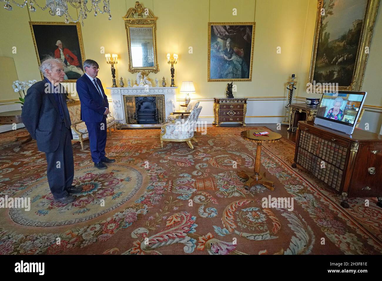 La reine Elizabeth II apparaît sur un écran par videolink du château de Windsor, où elle est en résidence, pendant un public virtuel pour recevoir David Constantine (à gauche), accompagné du poète lauréat Simon Armitage, et pour lui présenter la Médaille d'or de la reine pour la poésie, au palais de Buckingham, à Londres.Date de la photo: Jeudi 28 octobre 2021. Banque D'Images