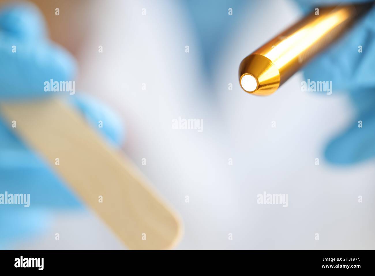 ORL examen de la gorge à l'aide d'une spatule en bois et d'une lampe de poche Banque D'Images