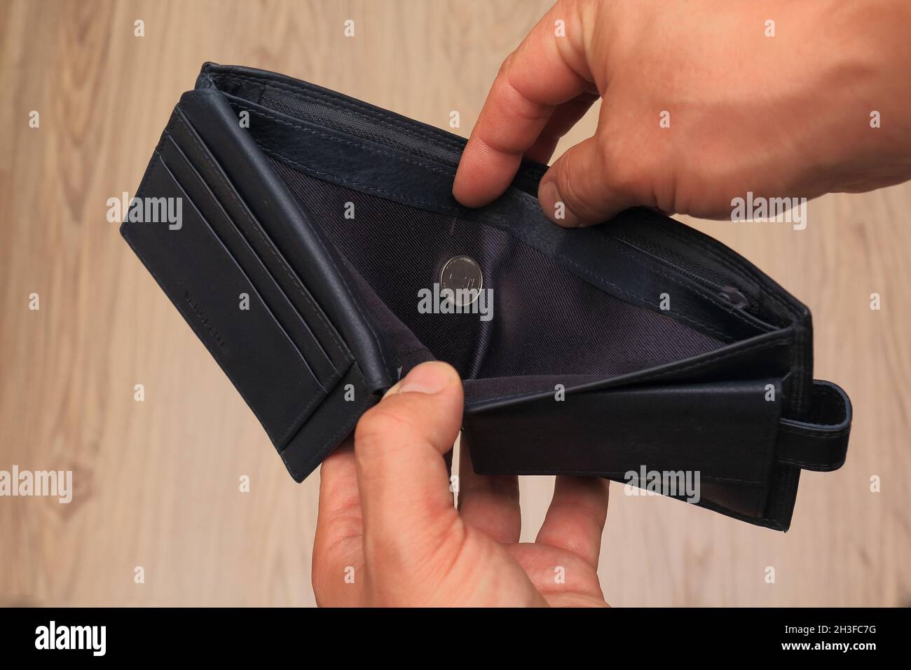 Pauvre homme main ouvrir portefeuille avec une pièce de un-shekel à la recherche de l'argent, cassé, faillite concept. Banque D'Images