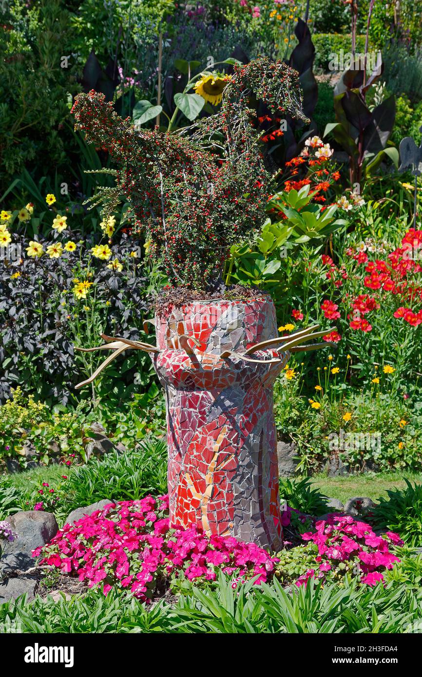 Scène de jardin, fleurs colorées, support de jardinière en mosaïque, morceaux de carreaux de céramique, la maison des géants,Île du Sud, Akaroa; Nouvelle-Zélande Banque D'Images