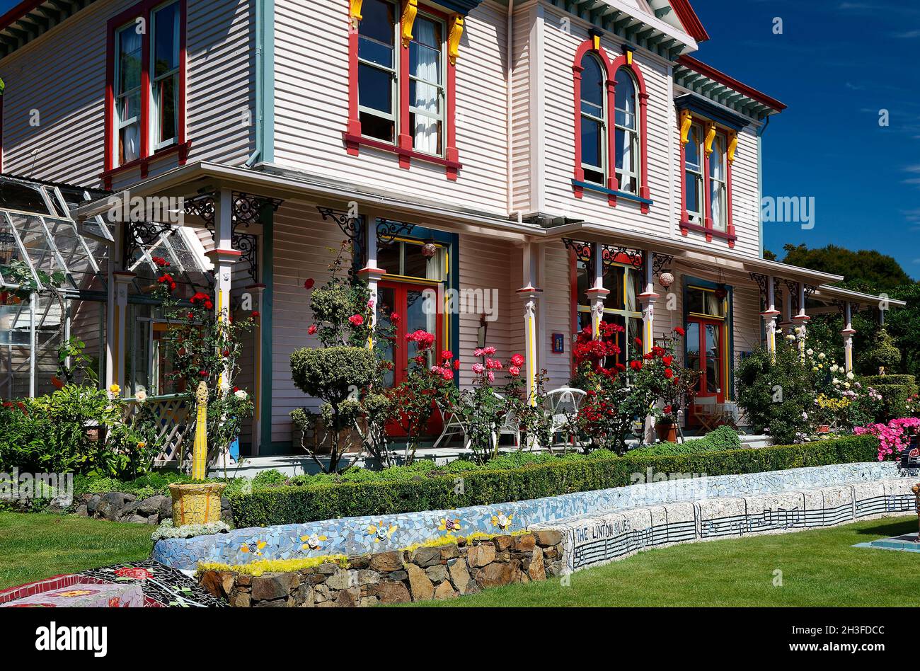 La maison des Giants; finitions multicolores, serre, jardin; banc de mosaïque;Fleurs, colorées; décoratives, île du Sud, Akaroa; Nouvelle-Zélande Banque D'Images